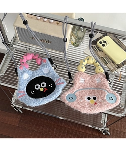 Detailed view of plush cartoon phone bags in pink and blue on a modern mesh shelf