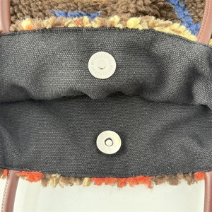 Detail of plush tote bag interior with dual magnetic snaps and thick canvas lining