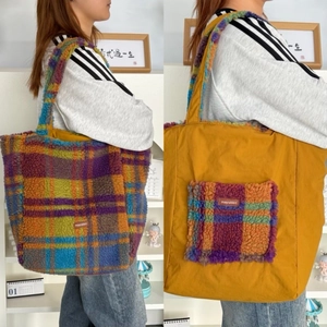 Close-up of a dual-sided plush tote bag featuring faux fur checkered texture and yellow nylon