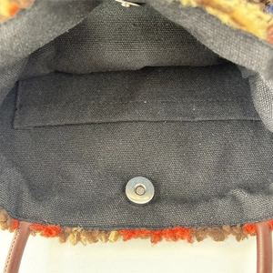 Detail showing plush tote bag interior with black canvas lining and magnetic clasp