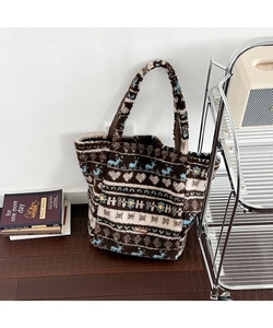 Detail of plush tote bag showing Nordic jacquard patterns with reindeer and heart motifs