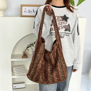 Detail of knitted tote bag with brown and green stripes showing thick boucle texture