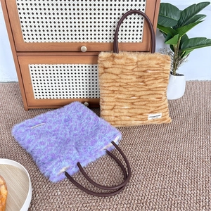 Detail of plush faux fur tote bags in leopard and tiger patterns with soft texture