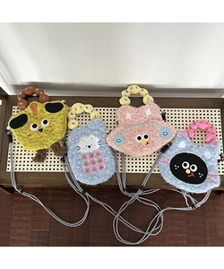Flat lay of four colorful cartoon plush crossbody phone bags on a wooden bench