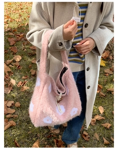 Pink plush tote bag detail with white floral embroidery and wooden toggle closure