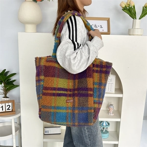 Detail of colorful plaid plush tote bag with soft texture and leather brand label