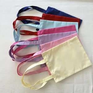 Thick blank canvas tote bags shown in seven vibrant colors with reinforced handles