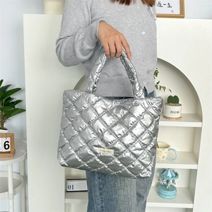 Close-up of a silver quilted tote bag with metallic finish and diamond-stitch detail