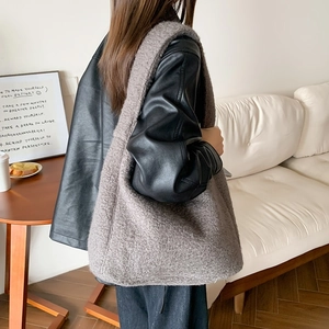 Detail of greyish-brown plush tote bag with soft texture worn on shoulder