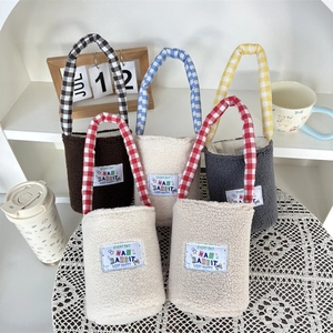 Detail view of colorful plush water bottle bags with checkered handles and letter embroidery