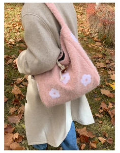 Detailed texture of pink plush tote bag with white flower embroidery and wooden button