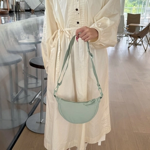 Detail of light green crescent bag with adjustable strap in high-density nylon material