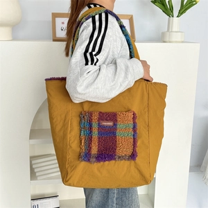 Detail of yellow tote bag featuring a colorful plaid plush pocket and mayrabbit label