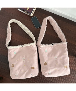 Detail of plush pink tote bag with festive Christmas bear embroidery and sherpa trim