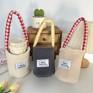 Close-up of soft plush water bottle bags with cartoon labels and checkered handles