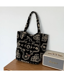 Detail of plush tote bag showing retro jacquard texture and brown leather label