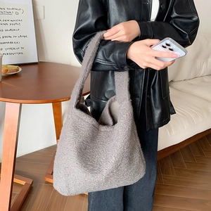 Detailed texture of the gray plush tote bag showing the soft lambswool material