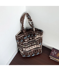 Close-up of plush tote bag showing reindeer and heart patterns in brown and white