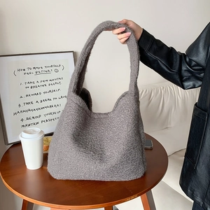 Detail of gray plush tote bag showing thick textured fabric in a cozy lifestyle setting