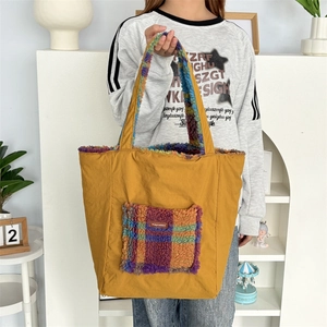 Close-up of yellow canvas tote bag with colorful plaid sherpa fleece pocket and lining