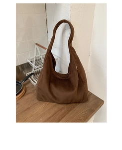 Deep brown plush tote bag with furry texture on wooden table with neutral background