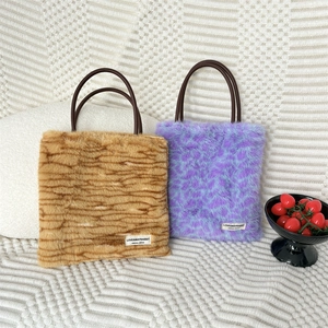 Detailed plush texture of winter tote bags in tiger and leopard patterns with round handles