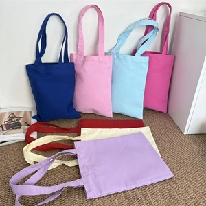 Detailed flat lay of thick canvas tote bags in diverse colors like navy, pink and red