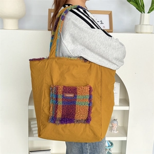 Model wearing a large ginger yellow tote bag with plaid plush pocket and straps