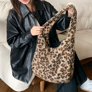Detail of plush leopard print tote bag showing soft faux fur texture and wide shoulder strap