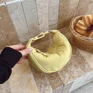 Detail of yellow nylon dumpling bag with adjustable plastic buckle and top zipper closure