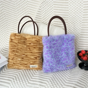 Detail of plush faux fur tote bags with leopard print and elegant round handles