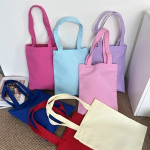 Detailed shot of seven colorful heavy canvas tote bags arranged in a fan shape display