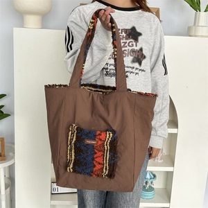 Detailed view of brown tote bag with colorful plush patchwork pocket and mayrabbit label