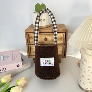Detail of plush brown water bottle carrier with checkered handles and rabbit graphic