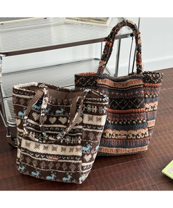 Detail of plush jacquard tote bags in brown and grey with reindeer and heart patterns