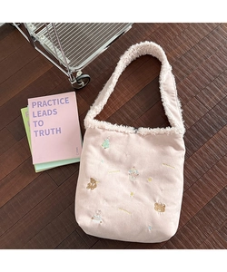 Detail of pink plush shoulder bag with winter embroidery and faux fur strap padding