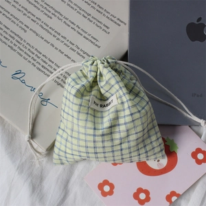 Detail of checkered drawstring storage pouch with fabric texture and woven brand label