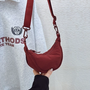 Detail of red water-resistant nylon crescent crossbody bag with adjustable wide strap