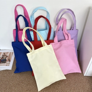 Stack of colorful heavy canvas tote bags showing variety of vibrant solid color options