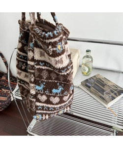 Close-up of winter plush tote bag showing reindeer jacquard pattern and soft texture