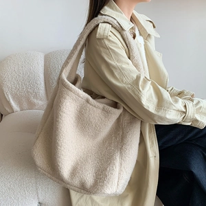 Spacious beige faux shearling tote bag shown on model for stylish everyday use