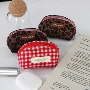 Detailed view of mini leopard print and plaid shell pouches for lipstick and small items