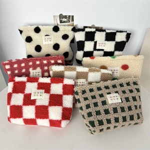 Close-up of soft plush cosmetic bags in various checkered and polka dot patterns