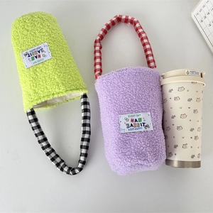 Detail of plush fleece water bottle sleeves in purple and neon green with checkered handles