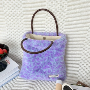 Macro shot of fluffy leopard print plush tote bag with leather handles and magnetic closure