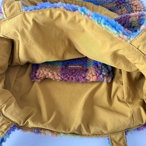 Close-up of multicolor plush tote with bright yellow lining and inner pocket