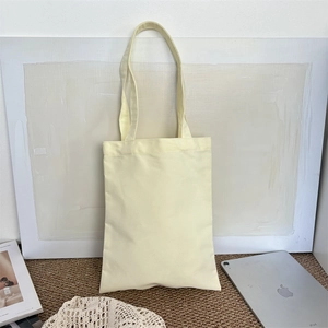 Detail shot of a minimalist blank cotton canvas tote bag on a textured carpet background