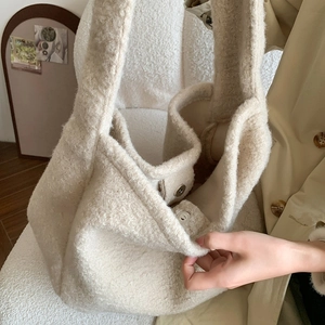 Detail of soft cream plush tote bag showing magnetic metal closure and spacious interior