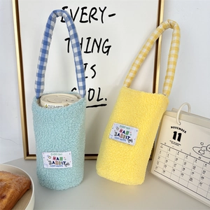 Close-up of soft lamb wool bottle sleeves in blue and yellow with checkered handles