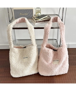 Detail view of soft plush crossbody bags in pink and off-white with SEEYOU logo